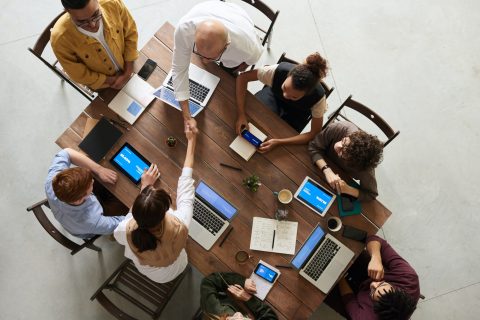 A group of people sitting around a table with laptops | WorkPlan Blog Image