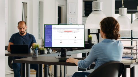 Drive your team's success with key insights. This image shows an office with a team manager looking at key insights in WorkPlan.